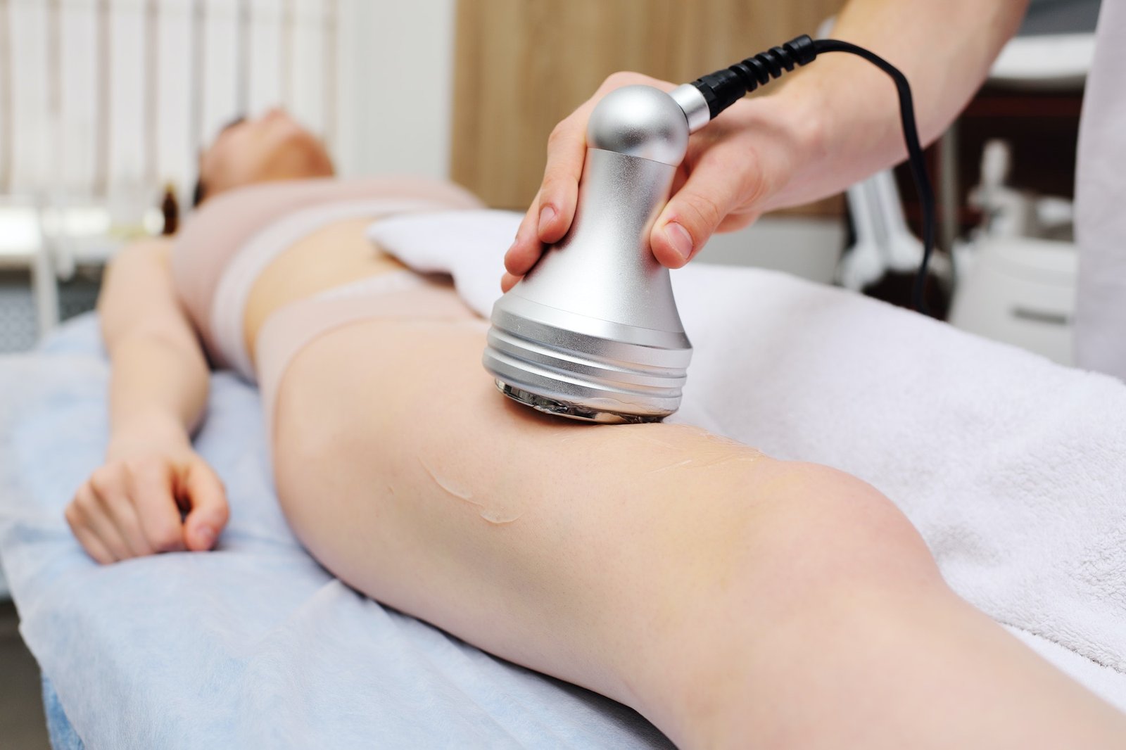 masseur performs cavitation to a young woman